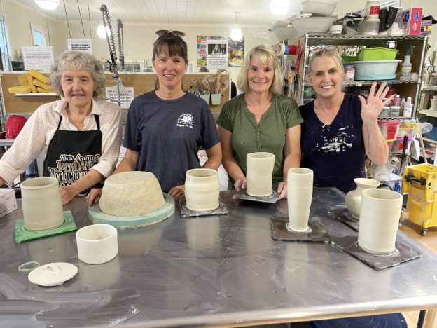 Carol, Lisa, Tina and Nancy standing behind fresh thrown pots